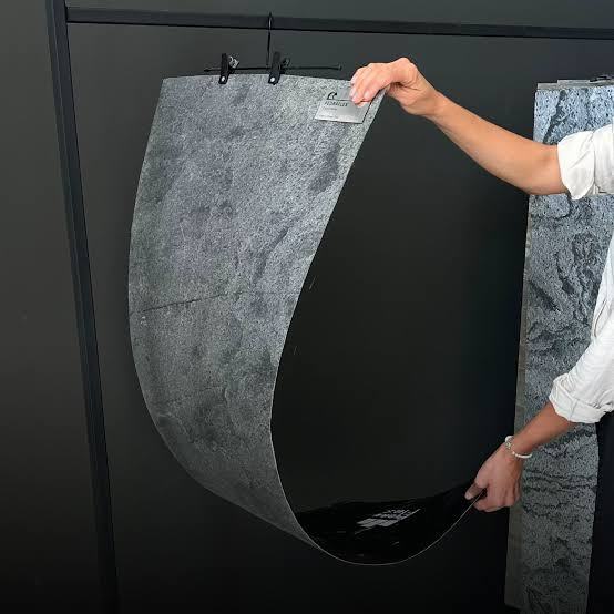 Placa símil piedra doblada a mano mostrando su flexibilidad